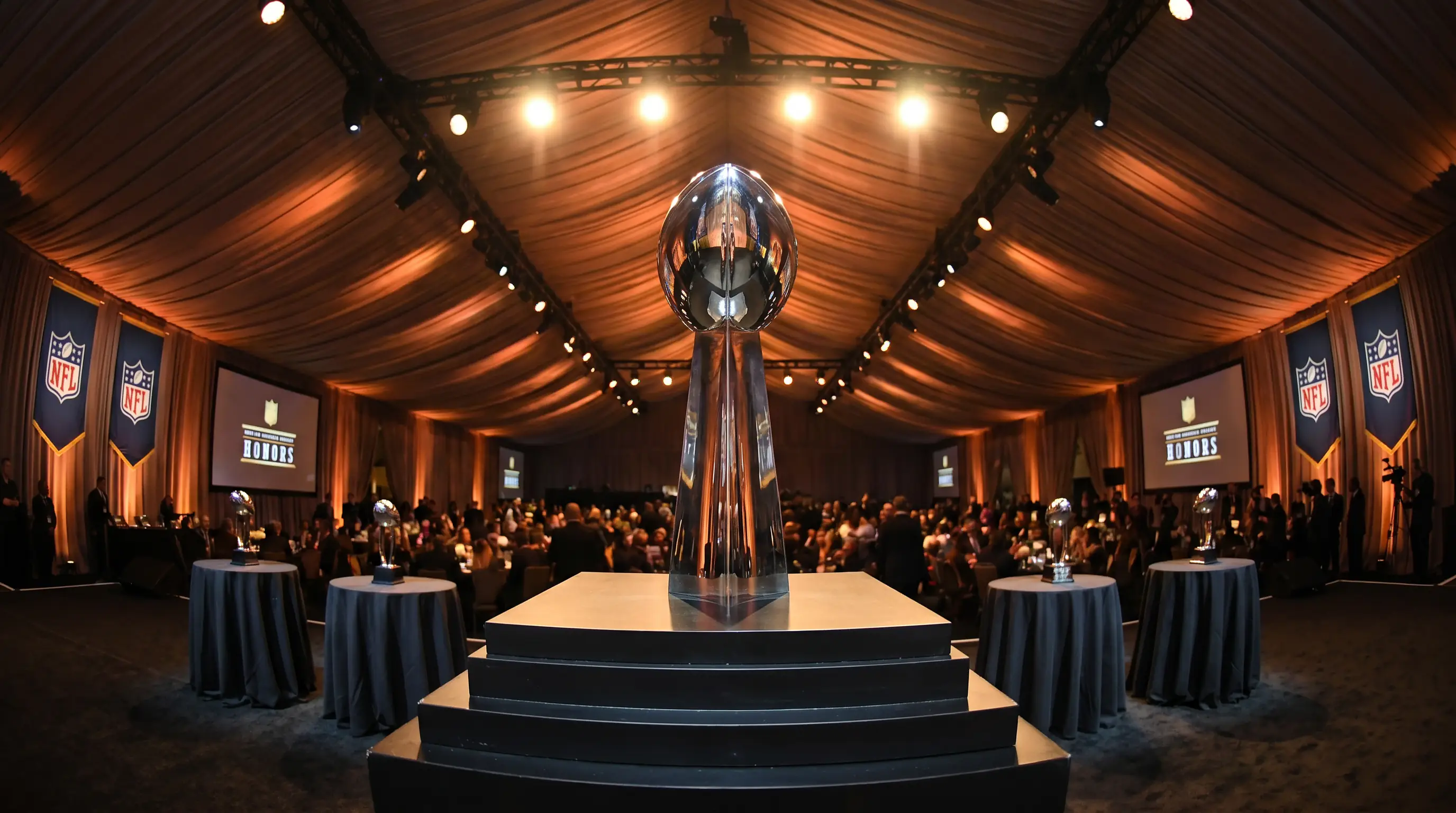 NFL MVP trophy on a podium under stage lights at the league's annual awards